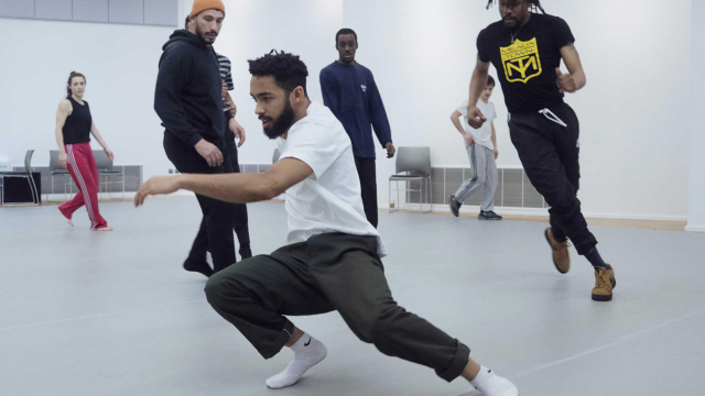 A group of dancers rehearsing in a dance studio.