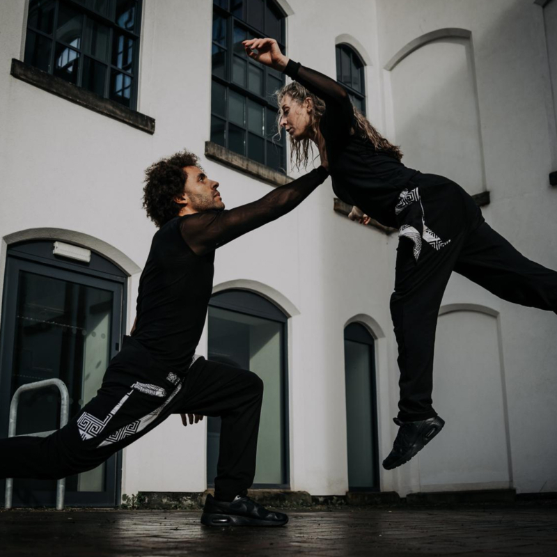 A dance duo rehearsing in a rehearsal space.