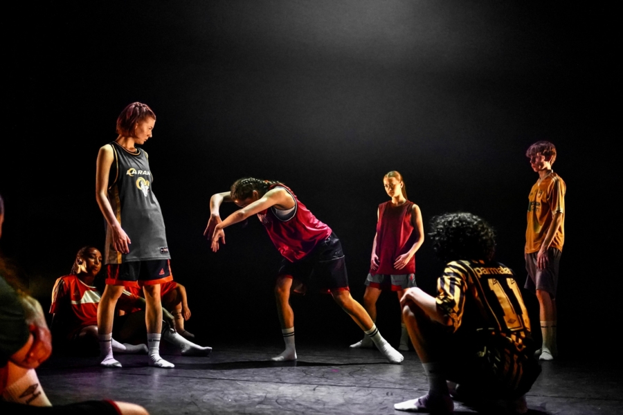 Group of performers rehearsing on stage.