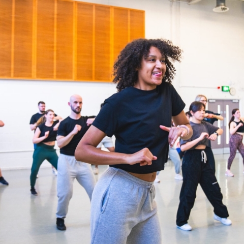 A group of dancers rehearsing in a dance studio.