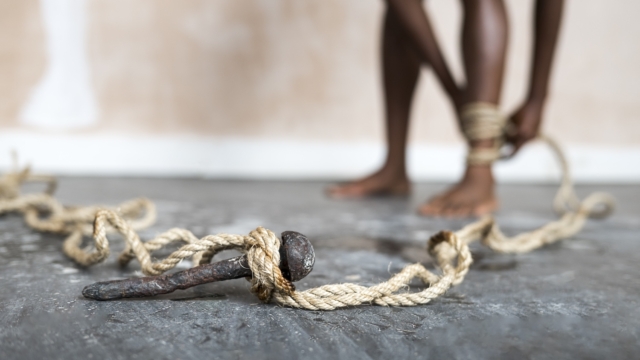 Rope is tied to a large iron nail and the ankle of a dancer.