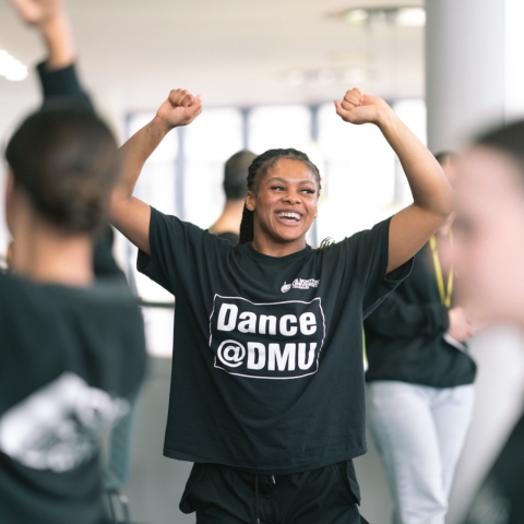 Young woman celebrates with her hands raised