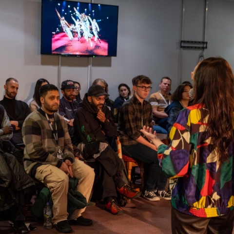 A group of people sat down listening to a speaker.